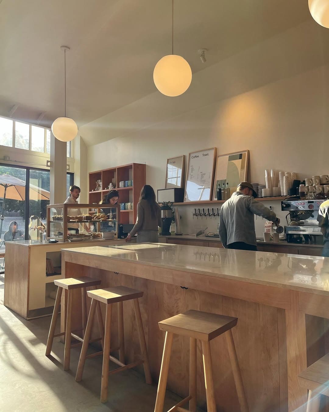 Customers enjoying coffee at a sunny window seat in espra Cafe